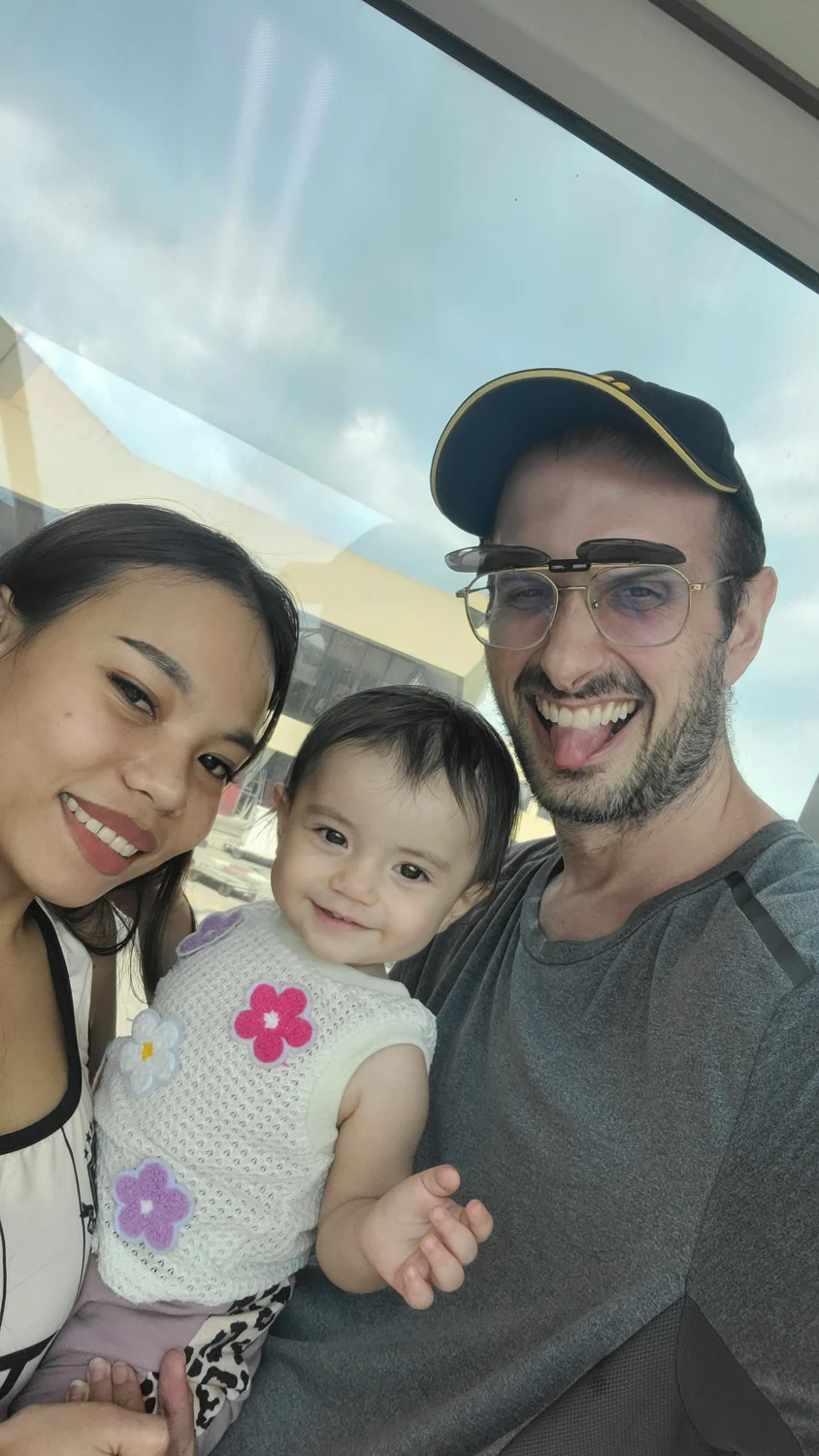 Todd, his wife and their daughter sharing a smile during their Thailand travels